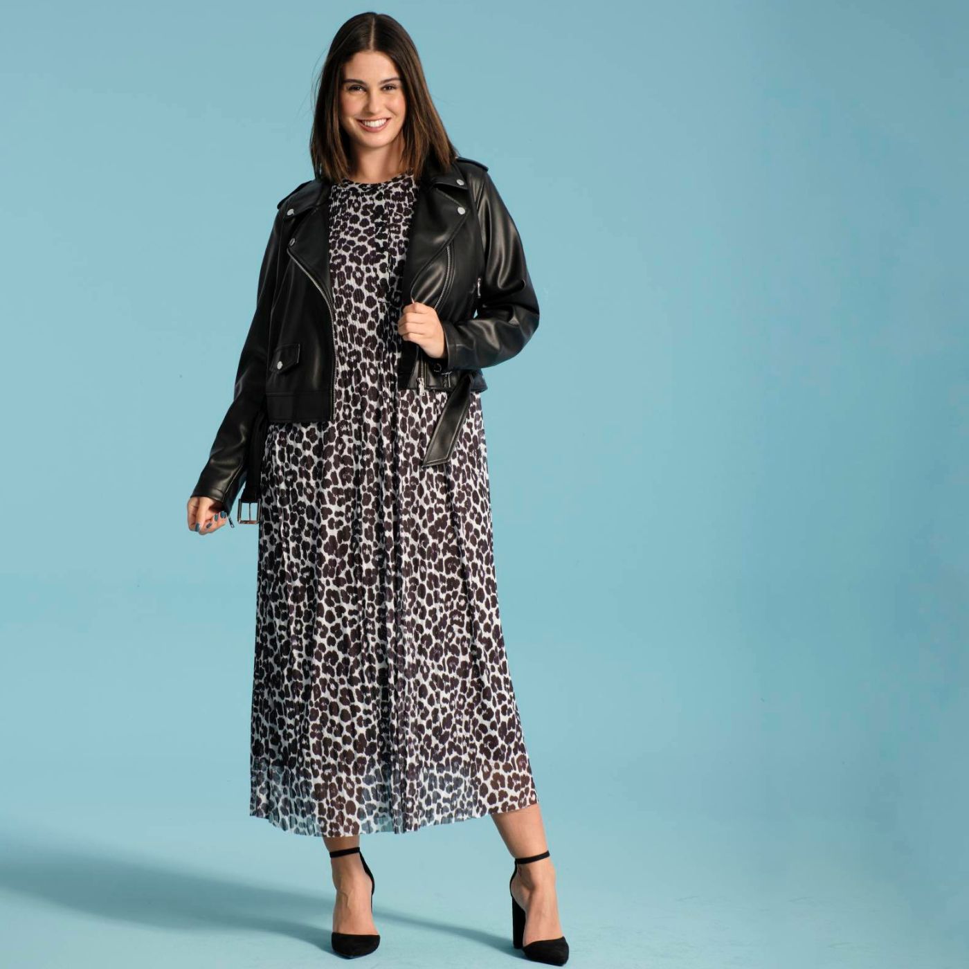A woman wearing an Ulla Popken sheer leopard print dress and a black leather jacket