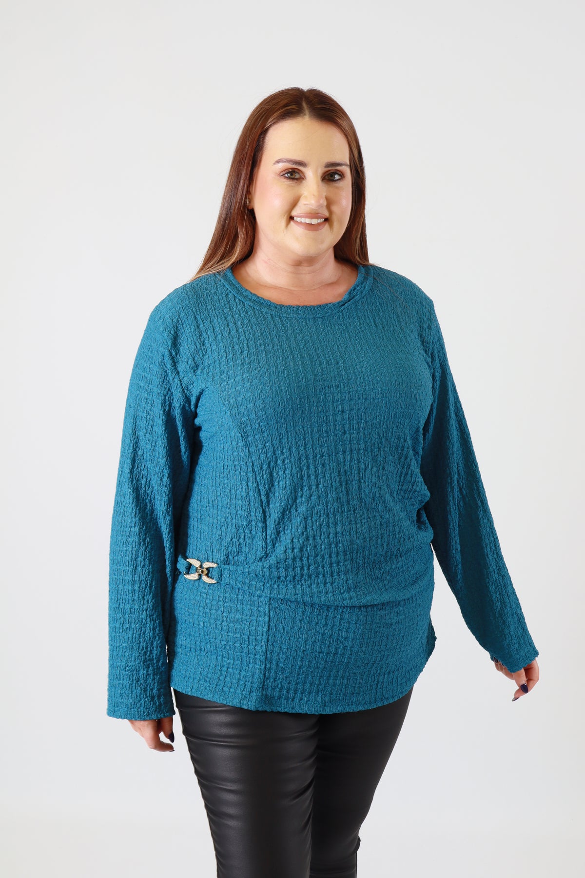 Person wearing a teal sweater on a white background