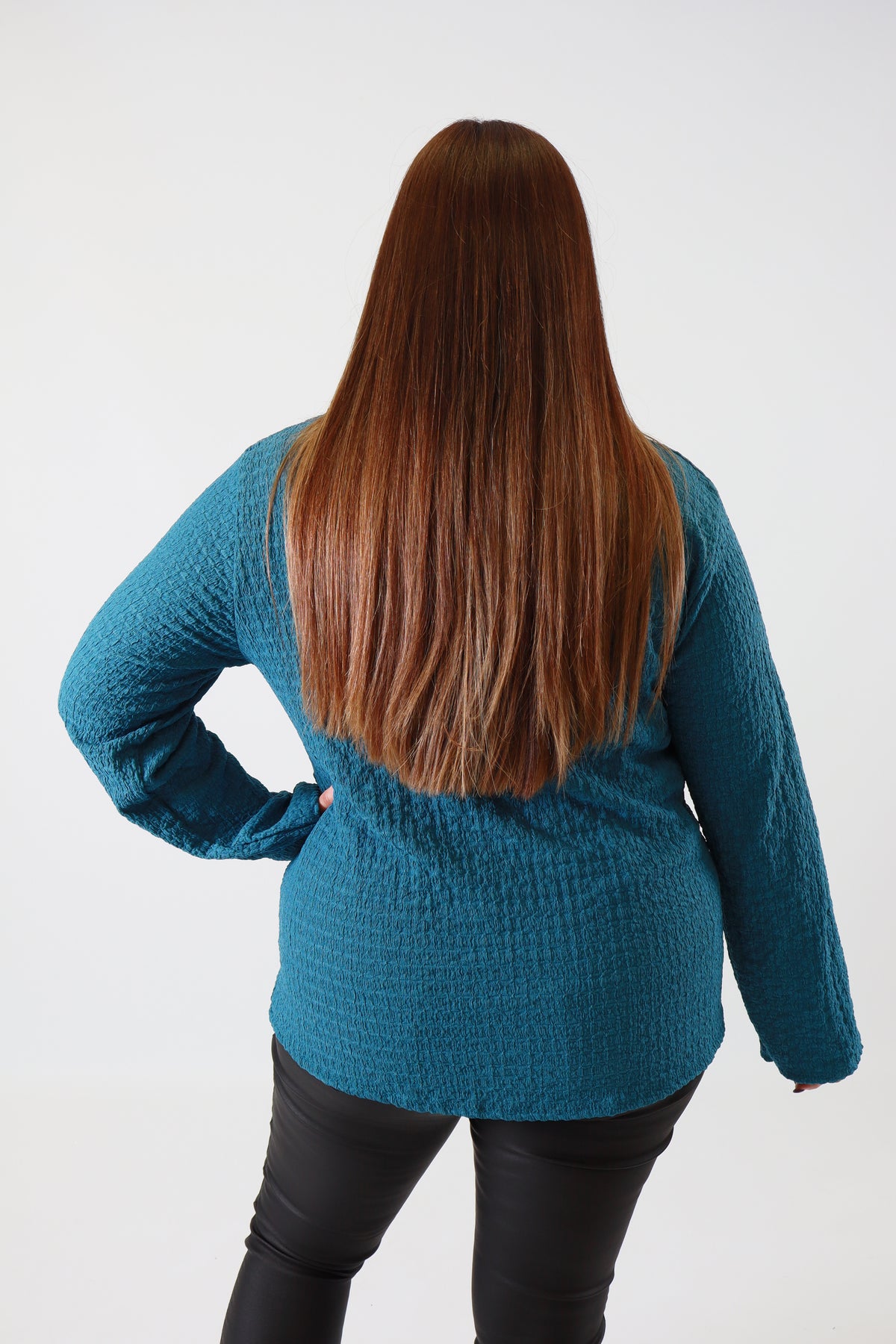 Person wearing a blue sweater on a white background