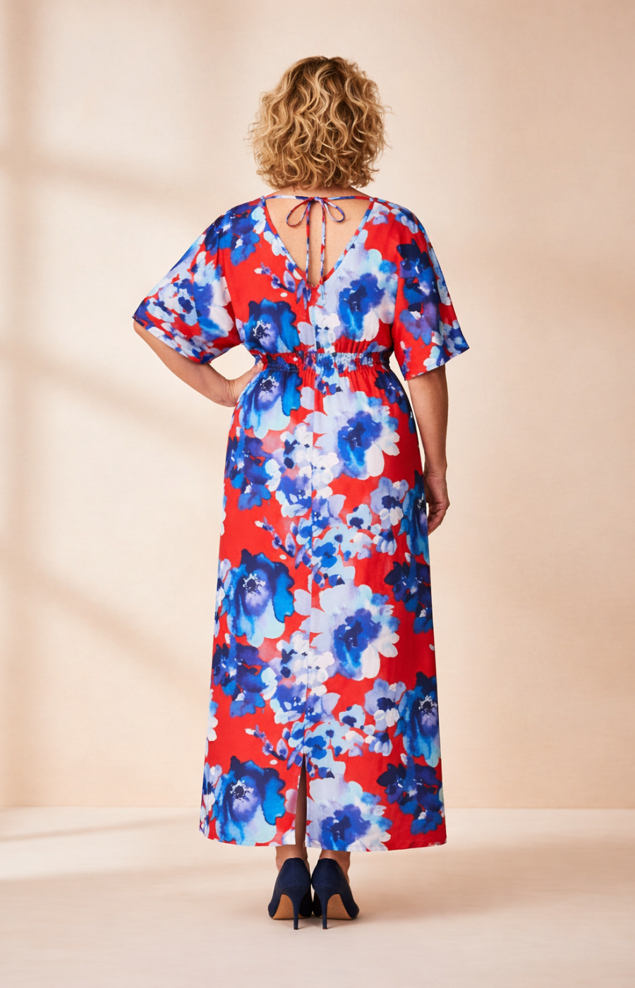 Woman wearing a brown floral dress against a beige background