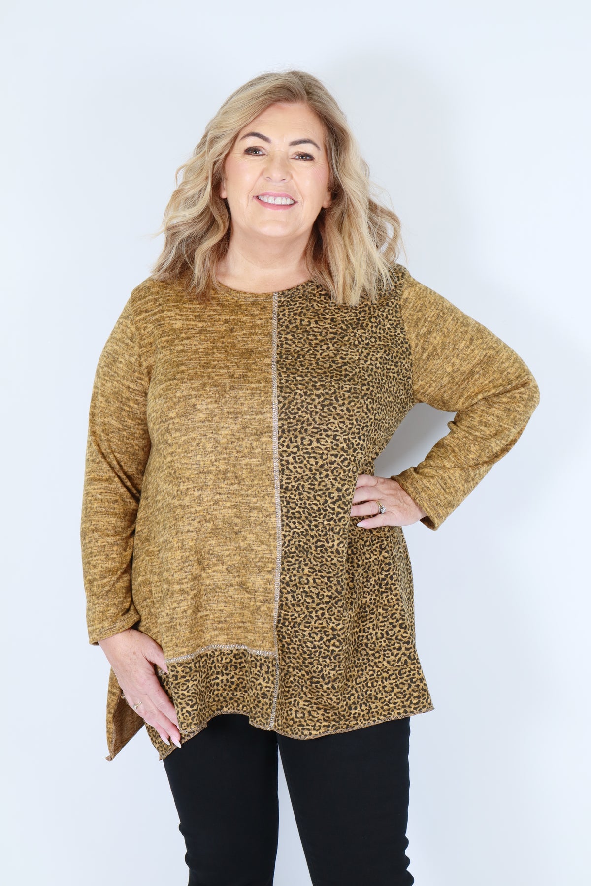 Woman wearing a yellow leopard print top on a white background
