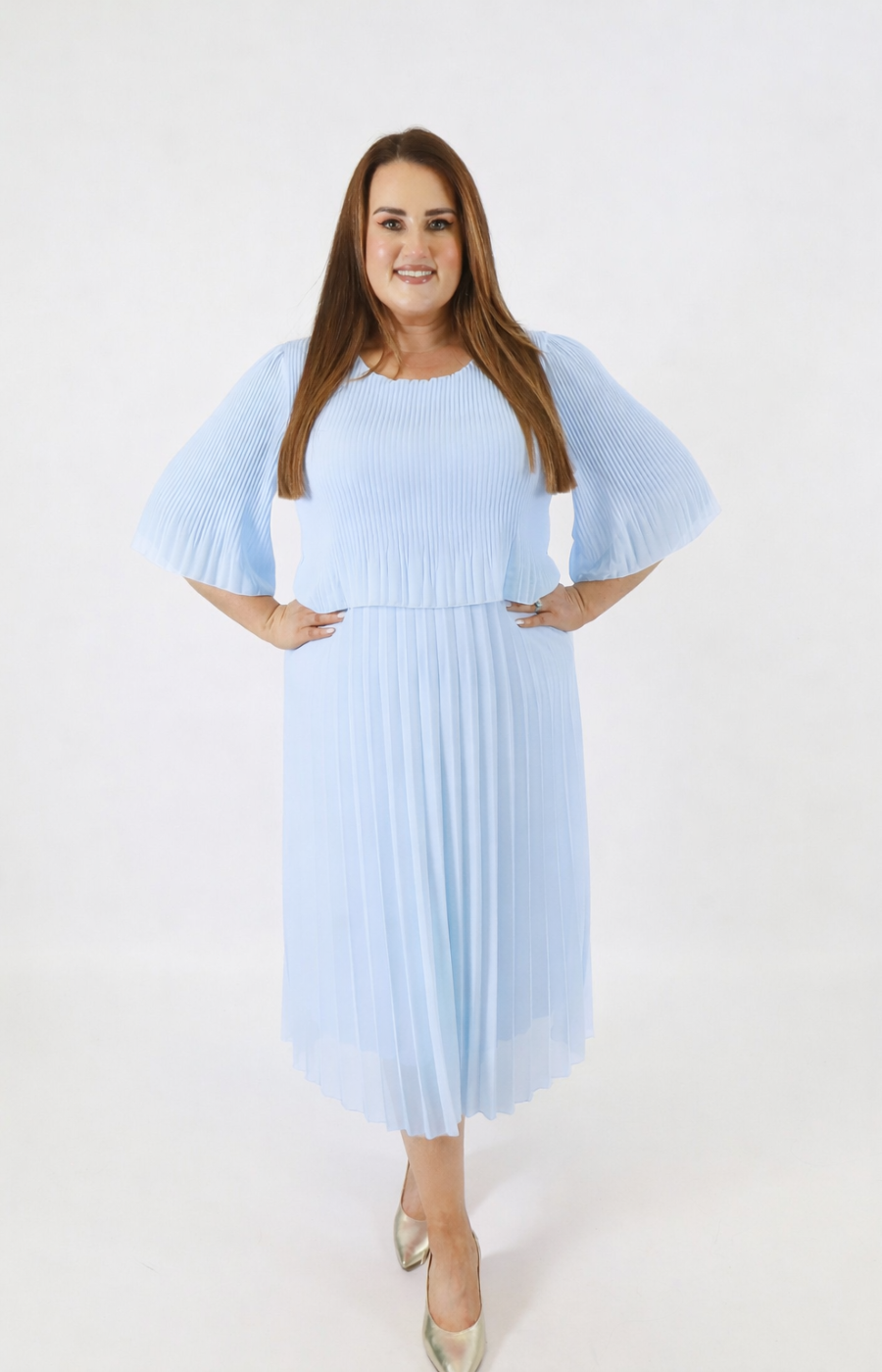 Woman wearing a light blue pleated dress on a white background