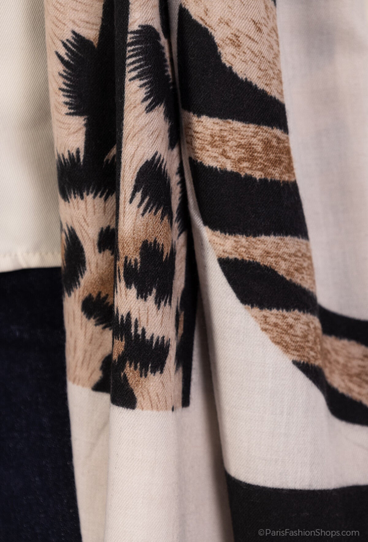 Close-up of a patterned fabric with black, brown, and beige colors.