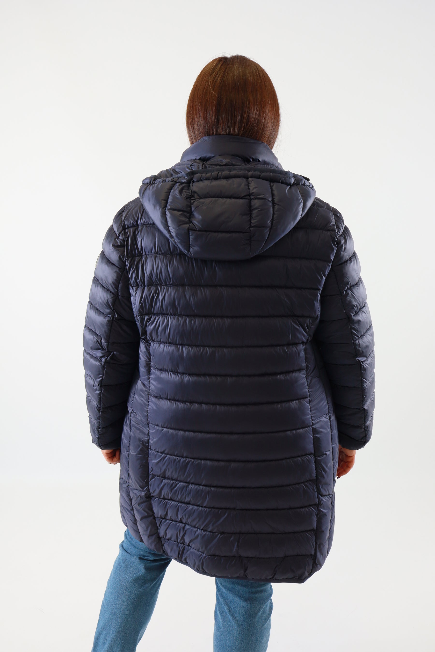 Person wearing a blue quilted puffer jacket on a white background