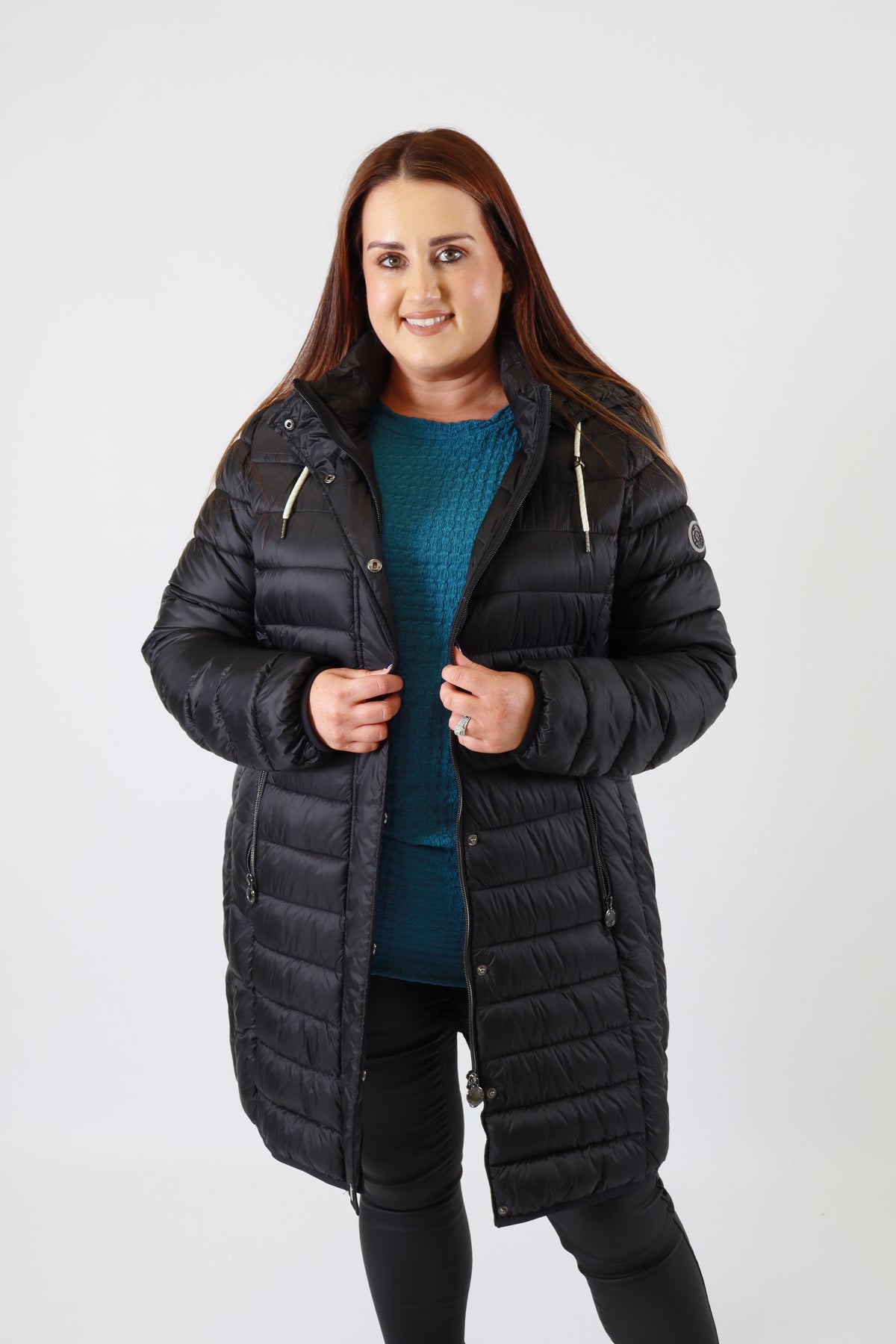 Woman wearing a black puffer jacket on a white background
