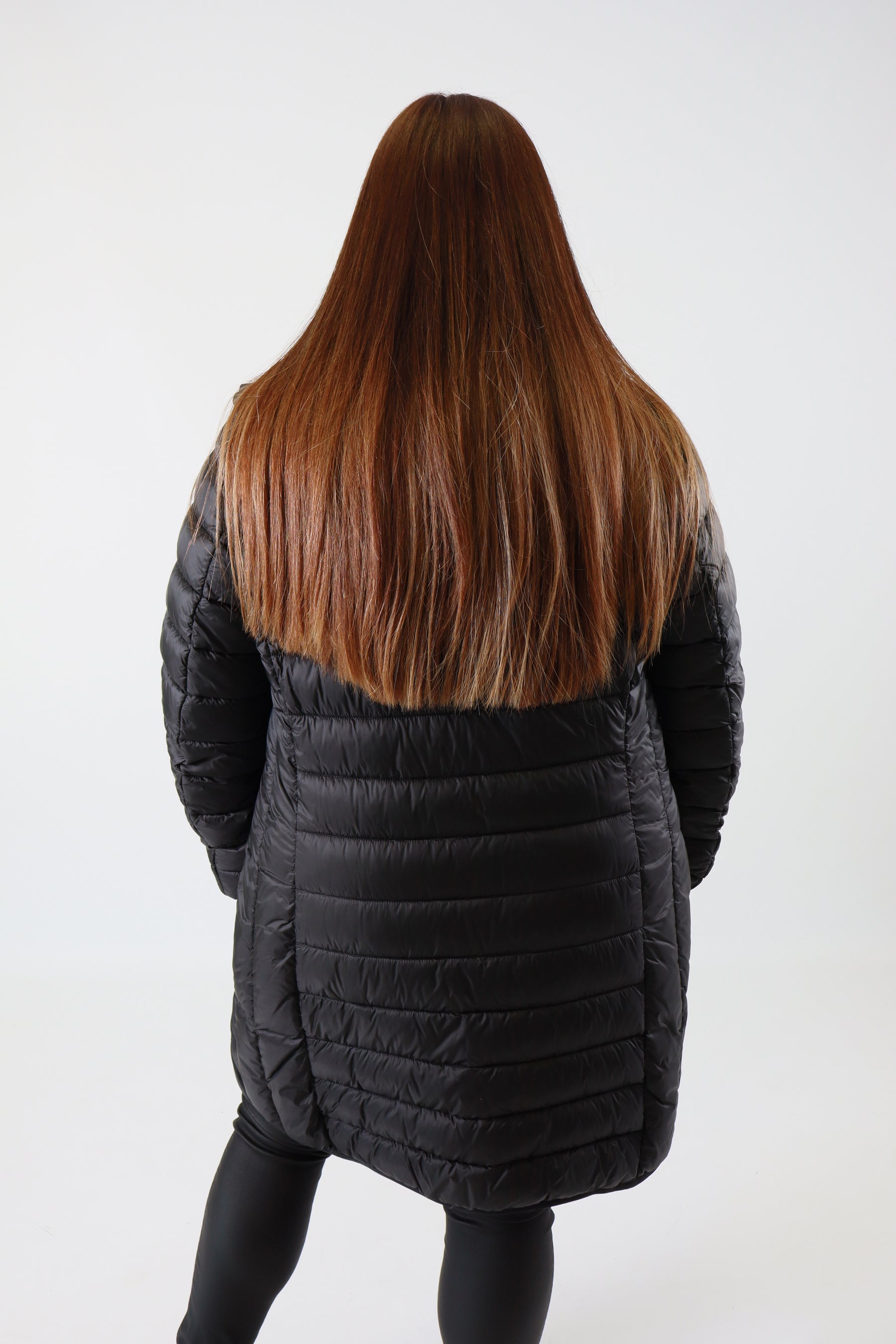 Person wearing a black coat on a white background