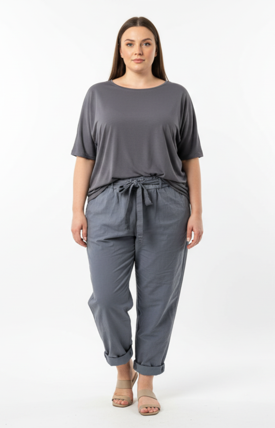 Woman wearing a gray t-shirt and grey joggers on a white background