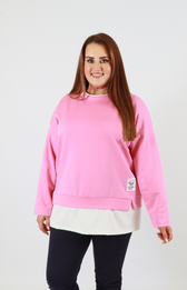 Woman wearing a pink sweatshirt with a white shirt underneath on a plain background