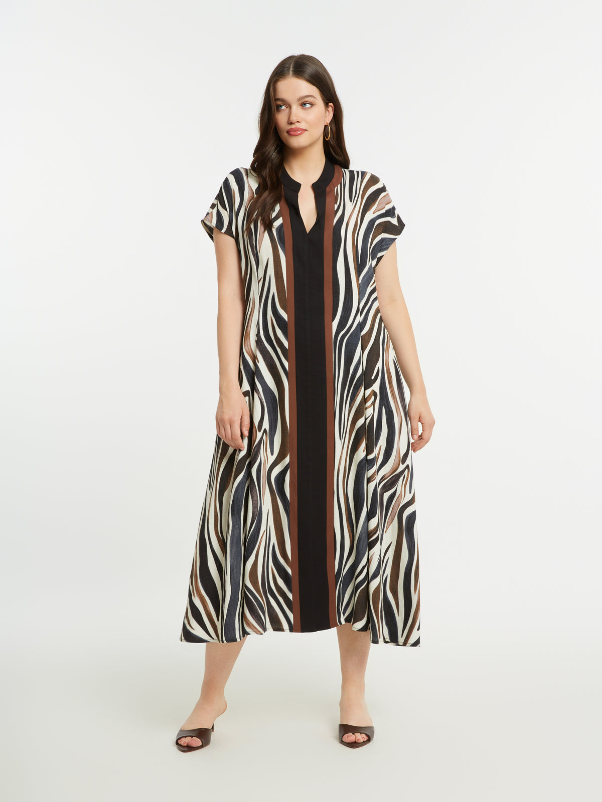 Woman wearing the Mat Animal Print Dress, a zebra print dress with a V neckline, short sleeves and an A-line shape on a white background