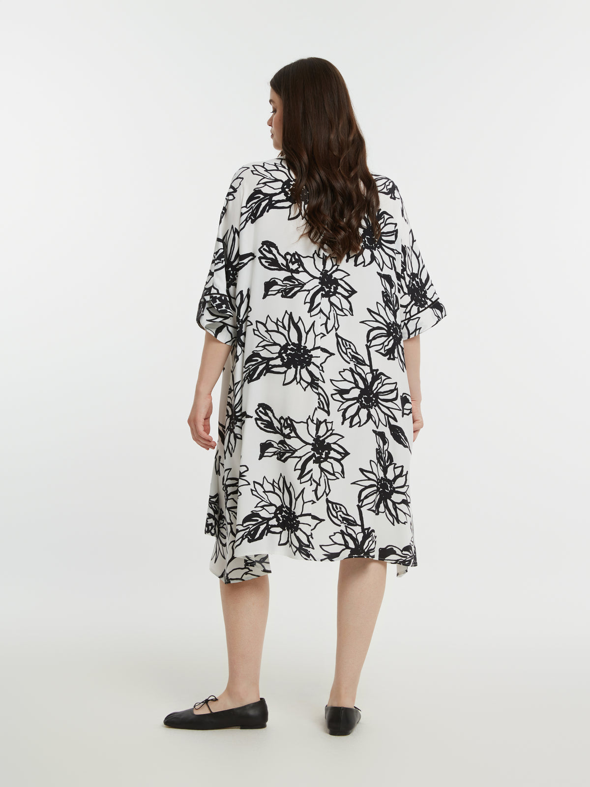 Woman wearing a black floral dress on a white background