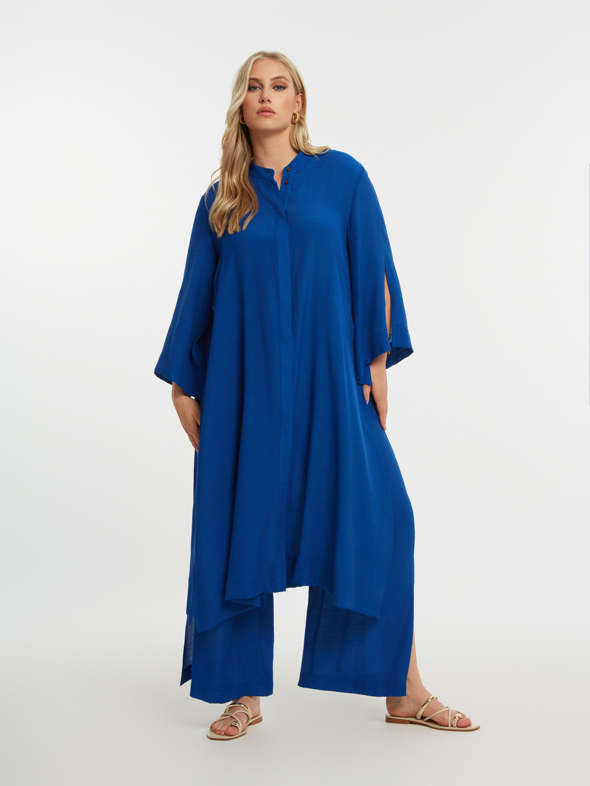 Woman wearing the Mat Longline Tunic in Blue
with a plain background