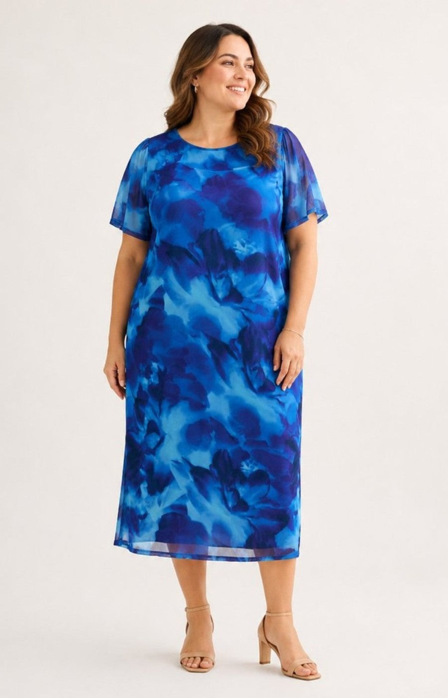 Woman wearing a blue abstract patterned dress on a white background