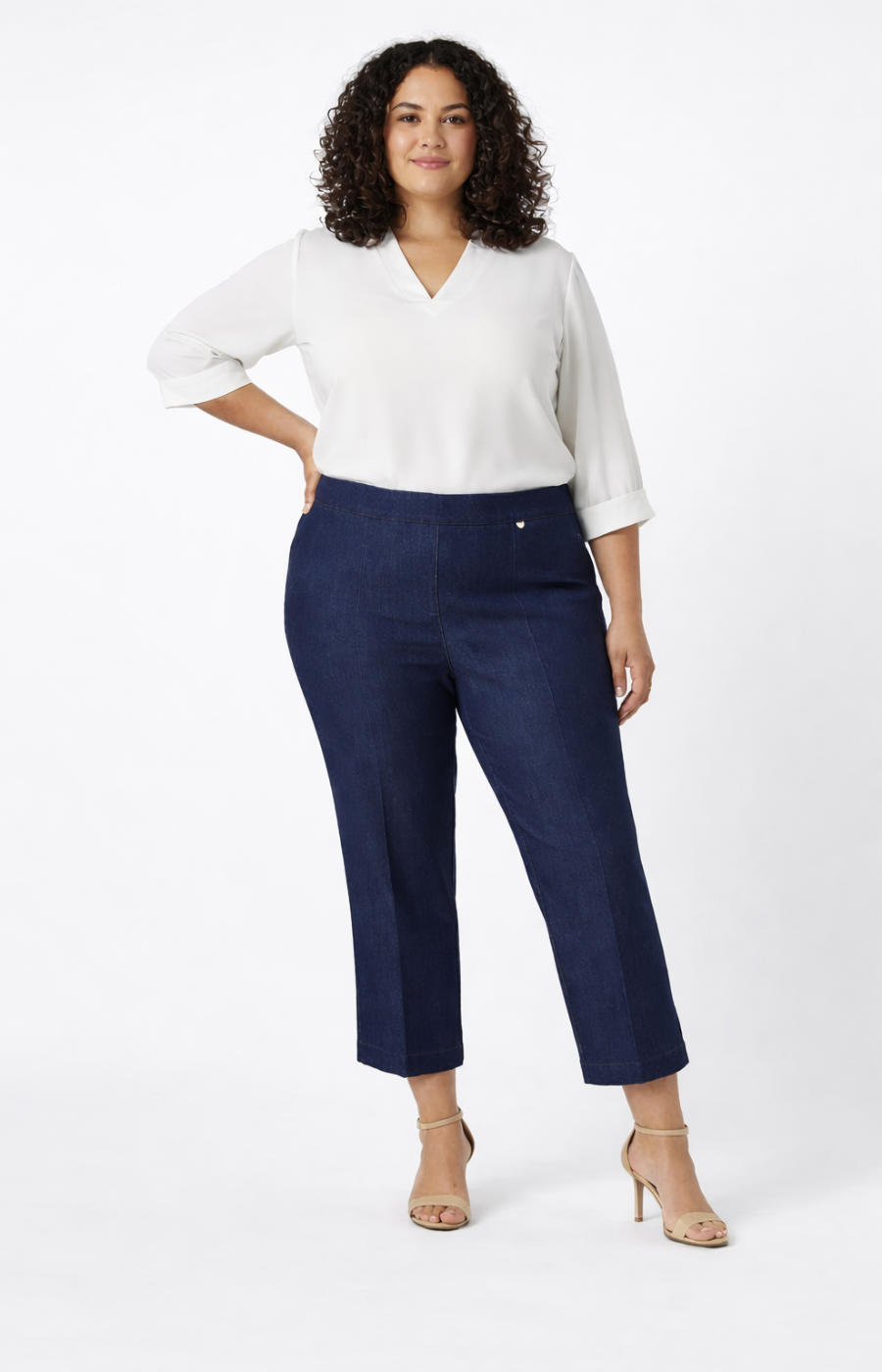 Woman wearing a white blouse and navy jeans on a white background
