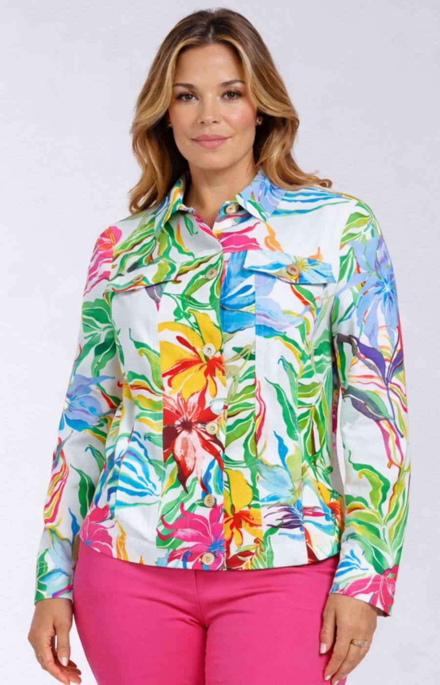 Woman wearing a colorful floral jacket with pink pants on a white background