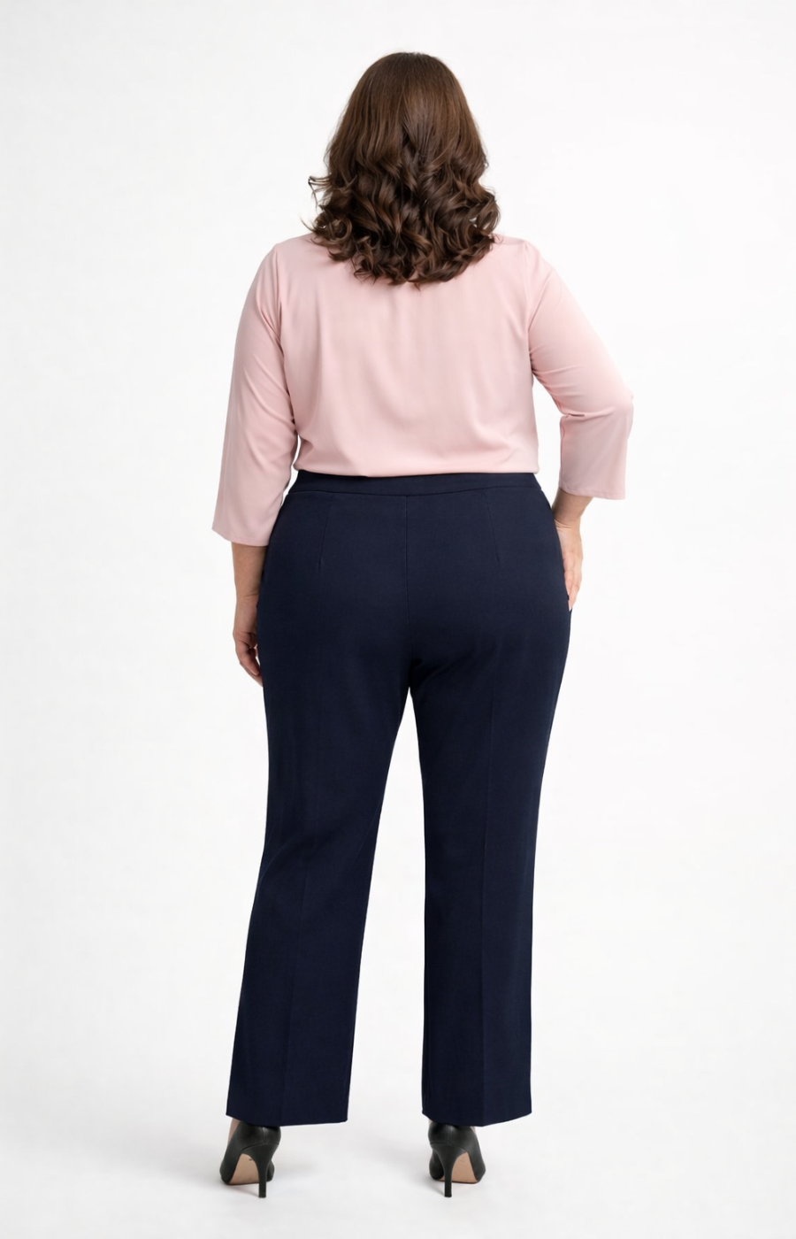 Person wearing a light pink blouse and navy trousers on a white background