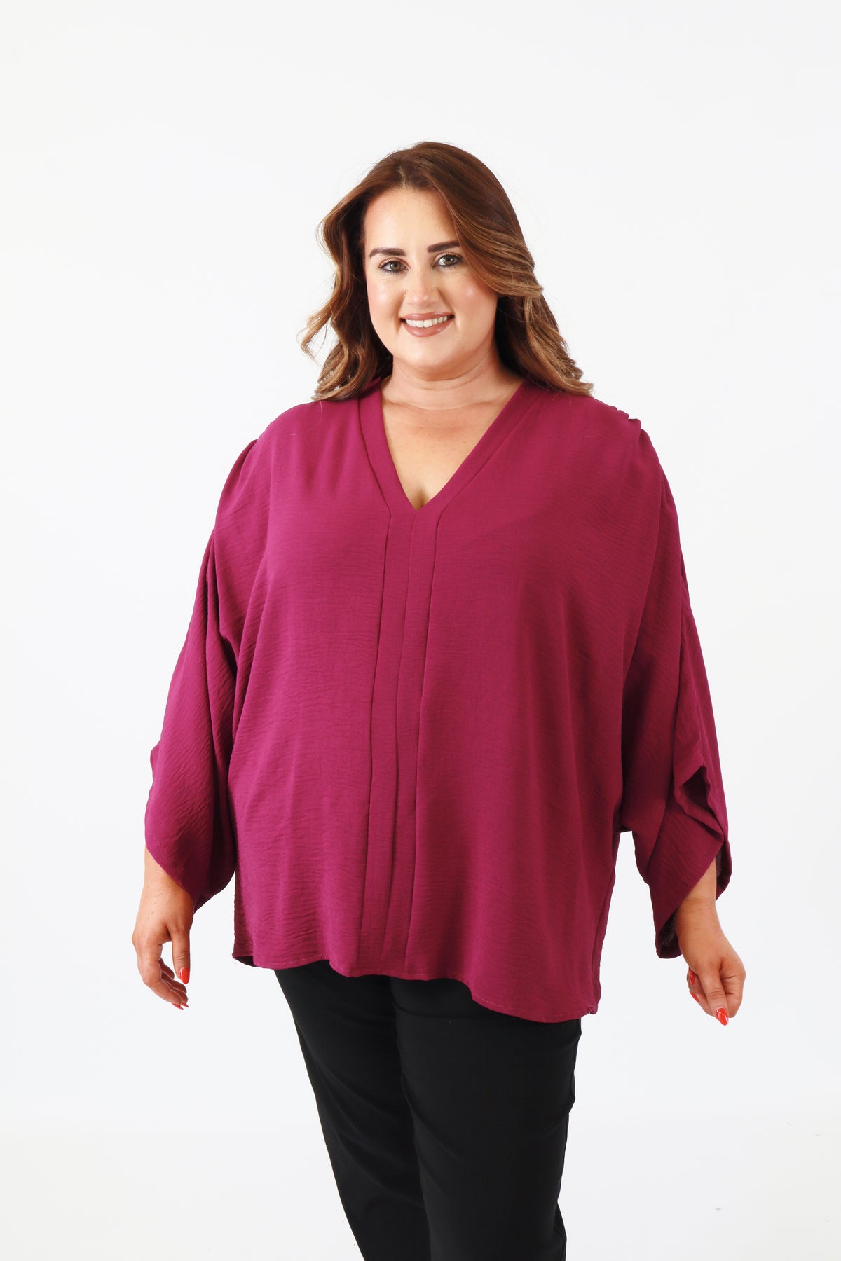 Woman wearing a magenta blouse on a white background