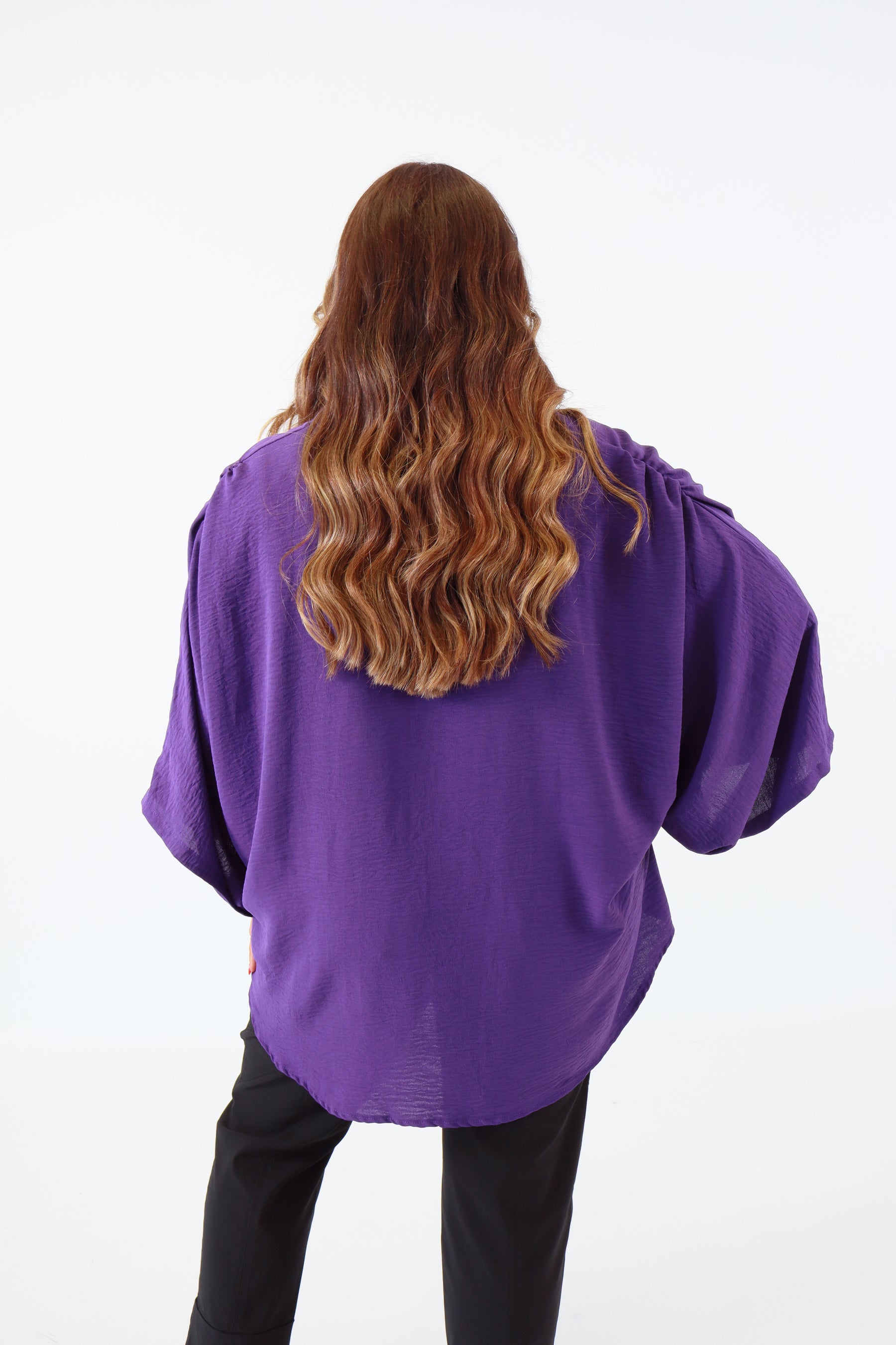 Person wearing a purple hoodie from an overhead perspective on a white background