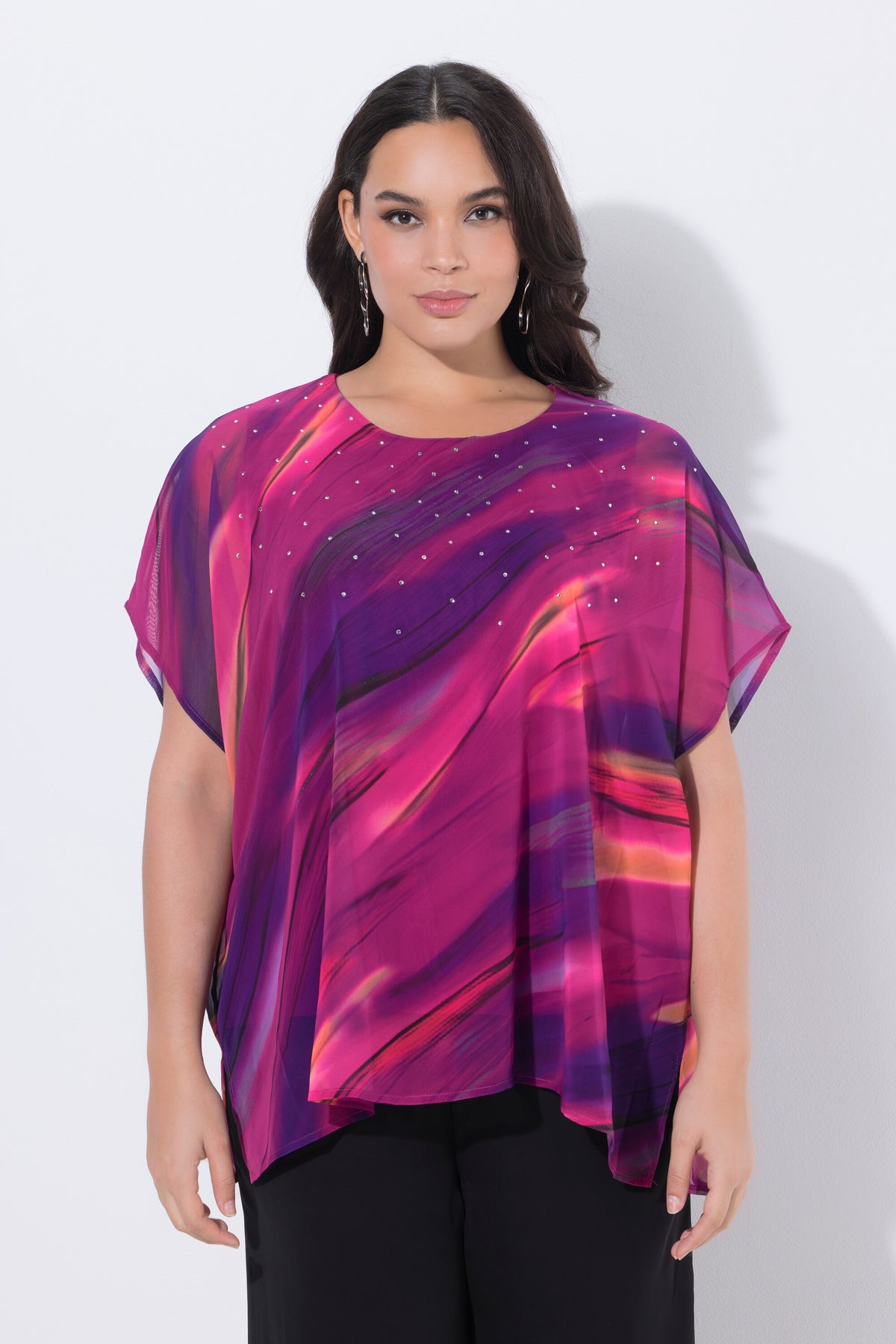Woman wearing the Ulla Popken Chiffon Blouse in Magenta, a vibrant, abstract-patterned top with a round neckline and short sleeves against a plain background