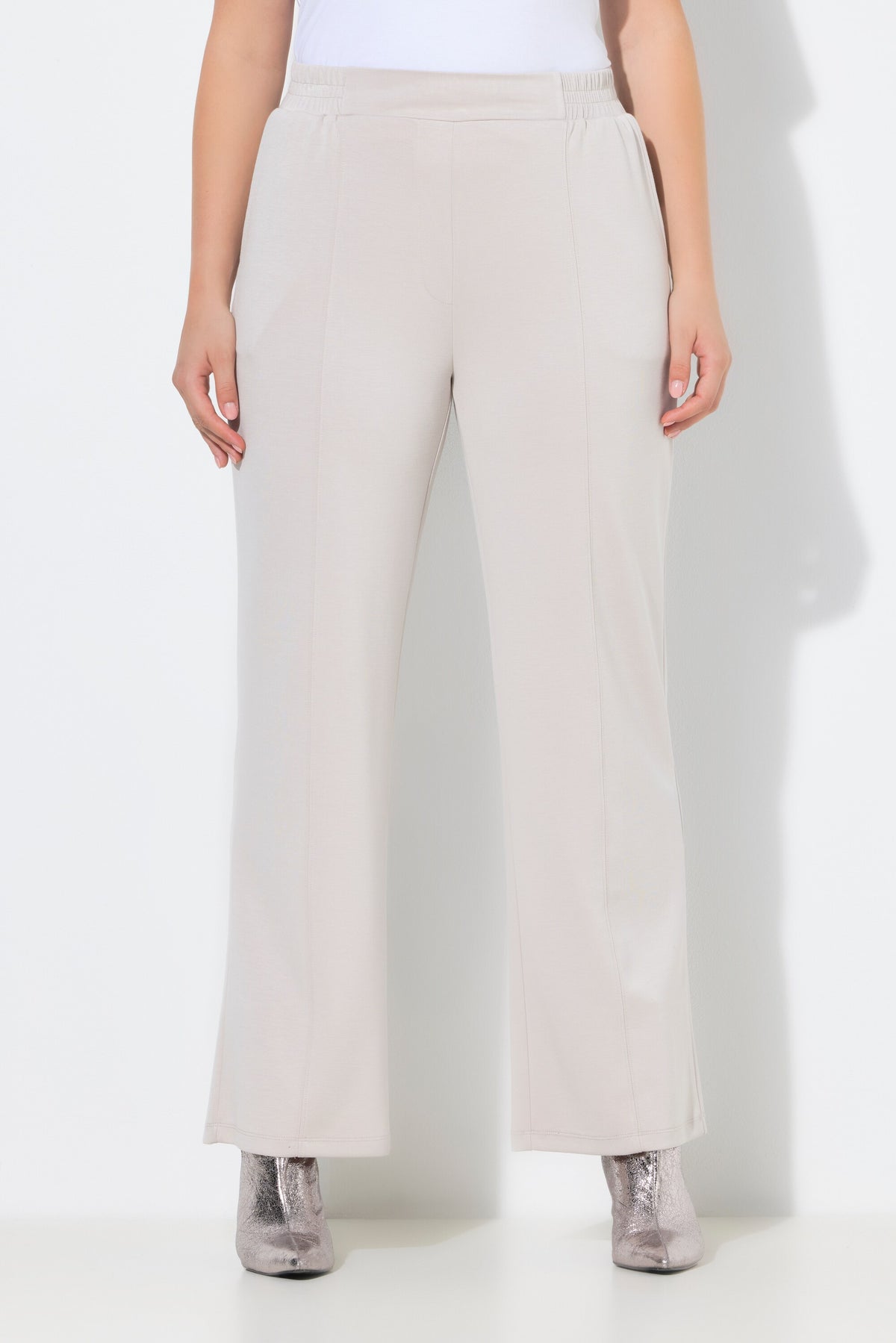 Women wearing the Ulla Popken Wide Leg Trouser in Beige, a wide leg trouser with an elasticated waistband, side pockets and piping down the front