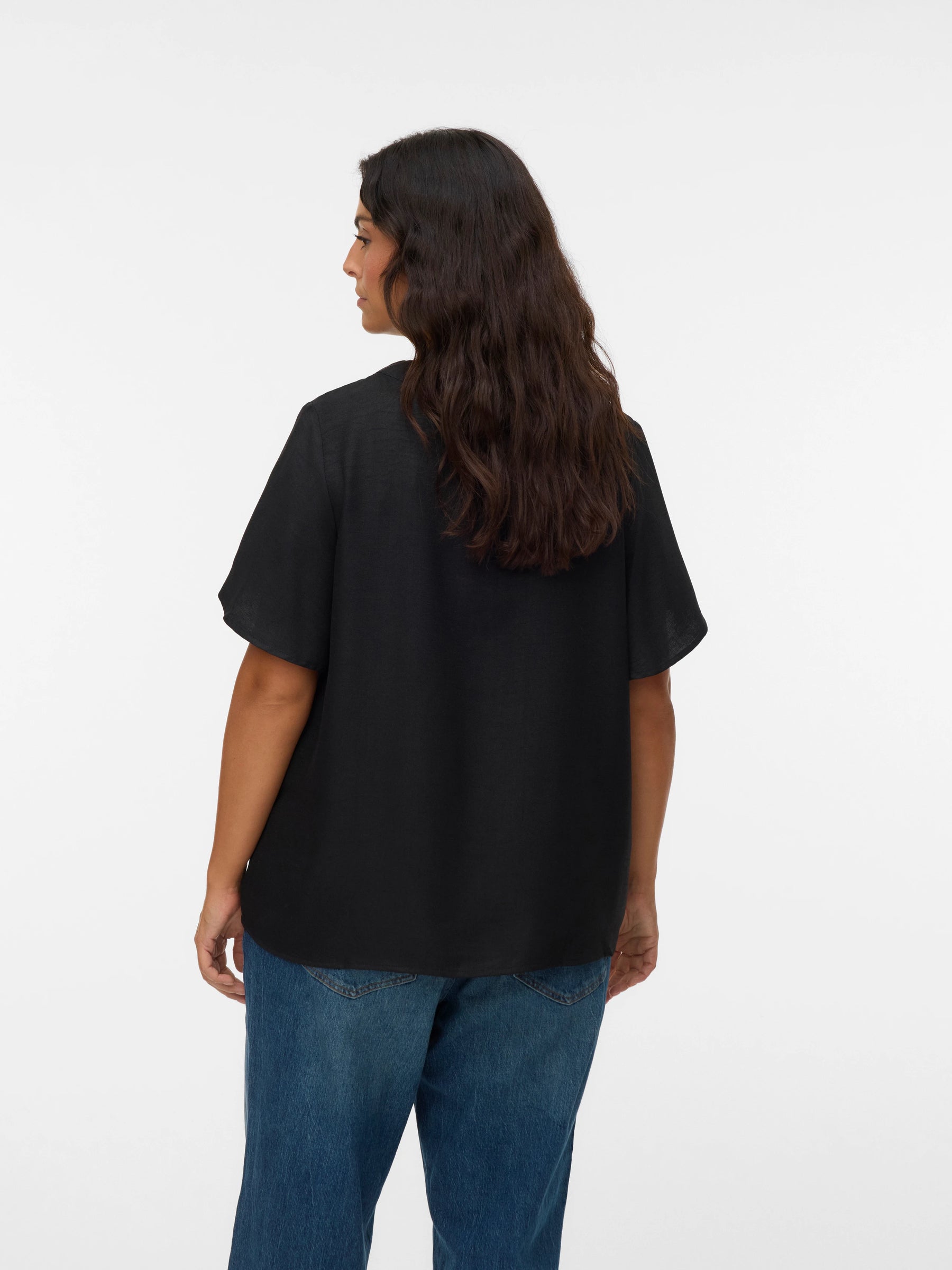 Person wearing a black t-shirt and blue jeans on a white background