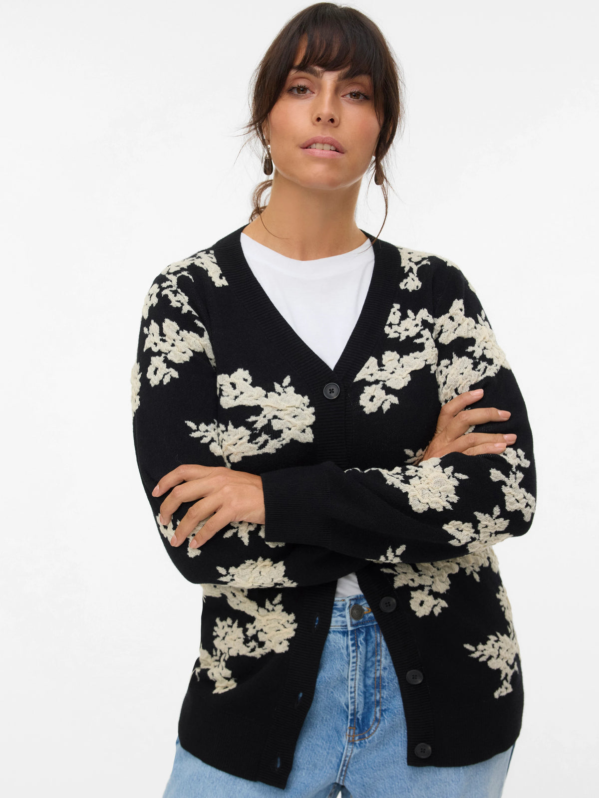 Woman wearing a black cardigan with white floral patterns on a white background