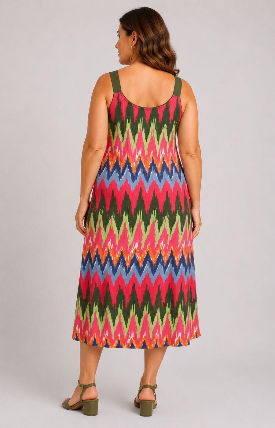 Woman wearing the Via Appia Due Zig-Zag Dress, a colorful zigzag patterned dress on a plain background