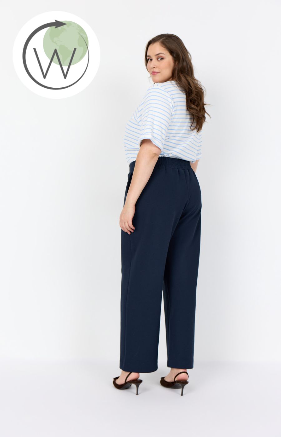 Person wearing the Wasabi Kufa Trousers in Navy, a navy wide-leg trousers and a striped shirt on a white background