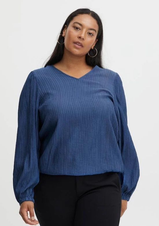 A dark haired woman wearing a blue Fransa Plus Pina blouse