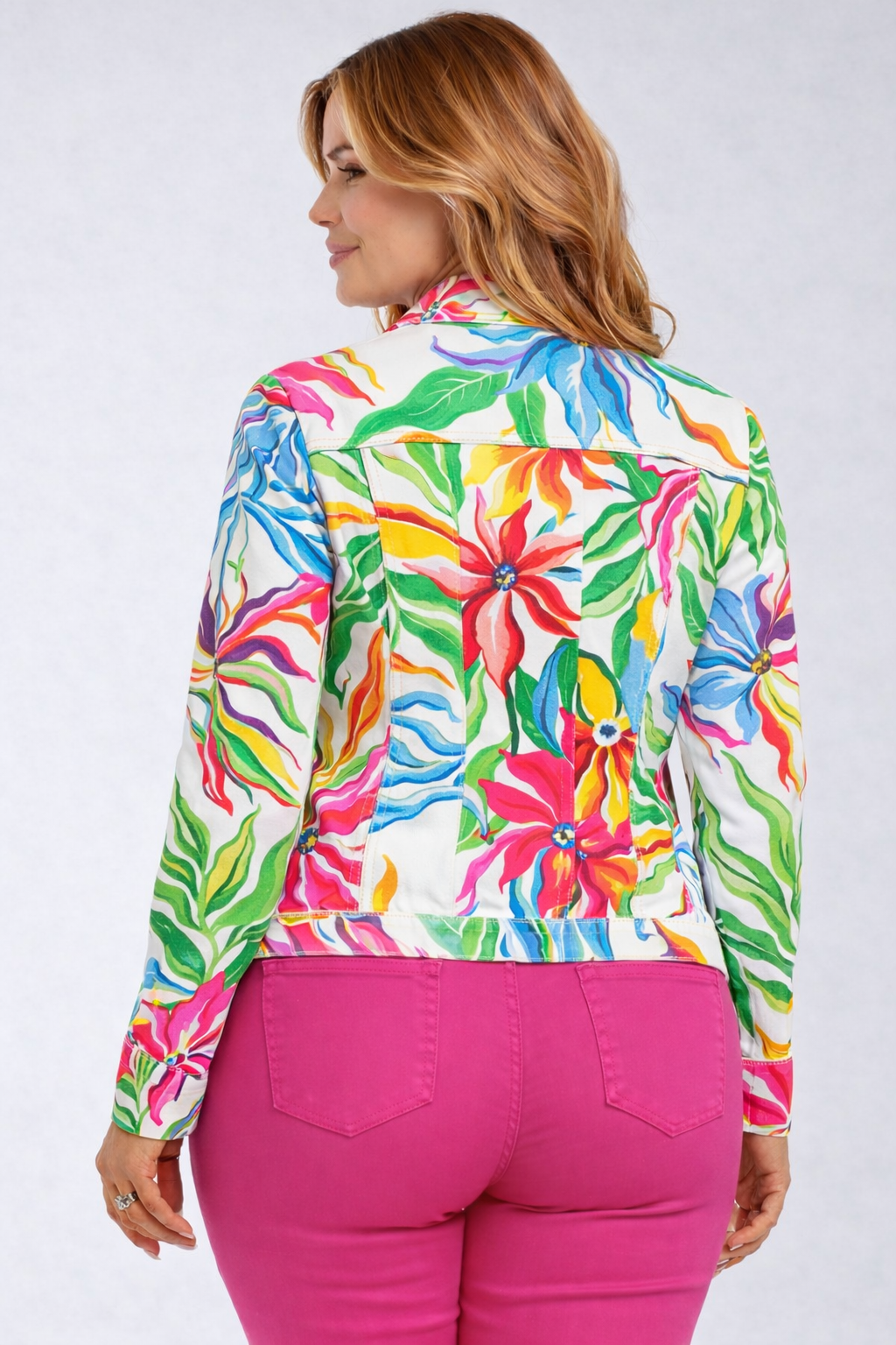 Woman wearing a tropical floral Jacket and pink pants on a white background