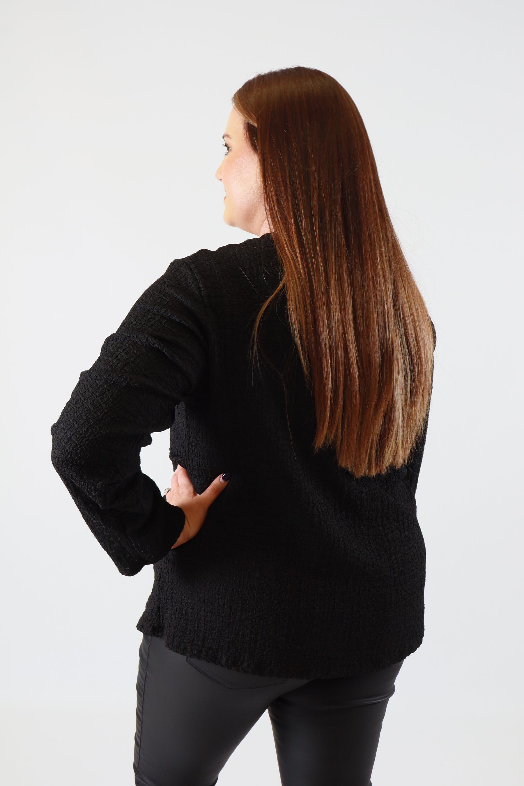 Person wearing a black sweater on a white background