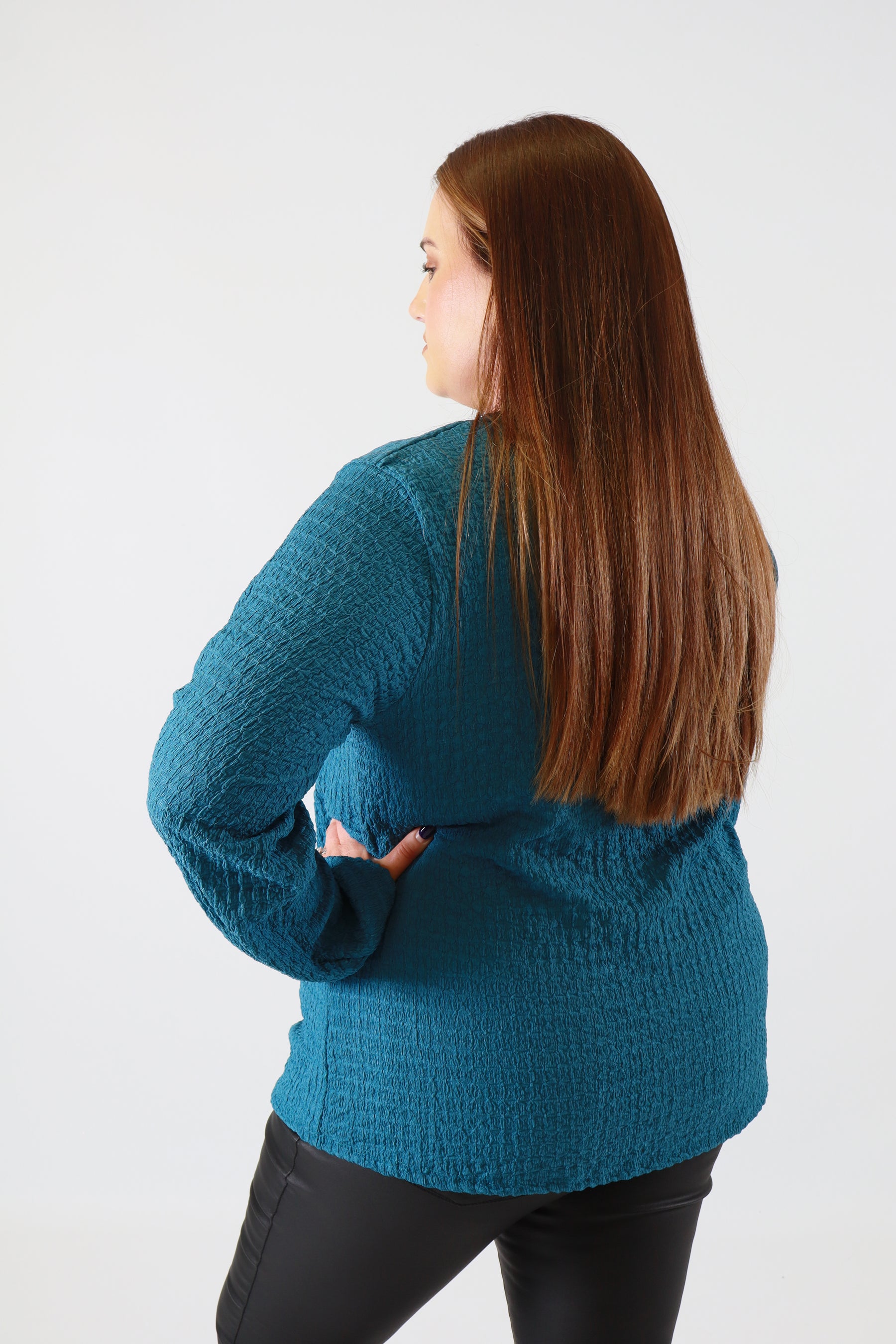 Person wearing a blue sweater on a white background