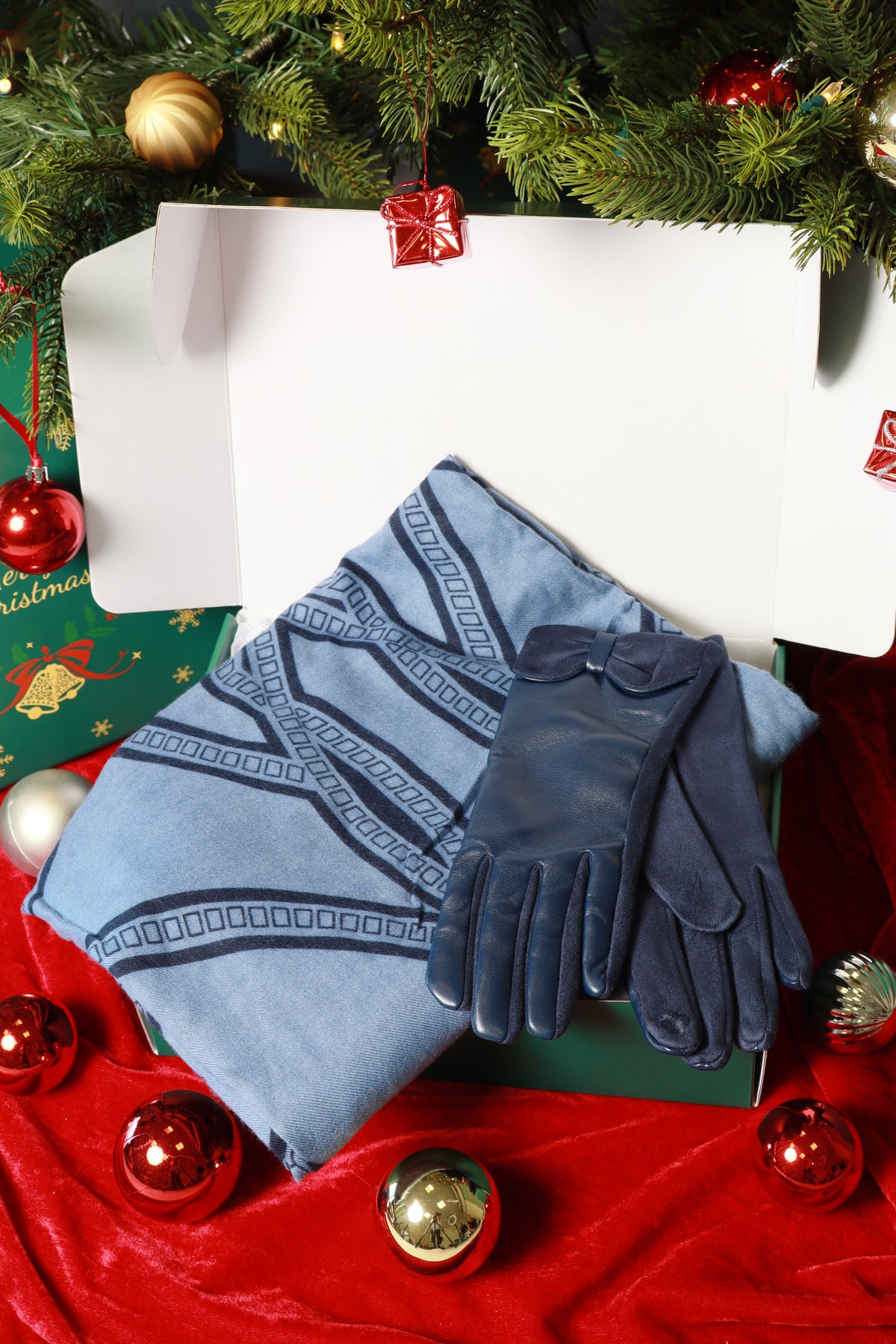 Pair of blue gloves on a green surface with Christmas decorations in the background