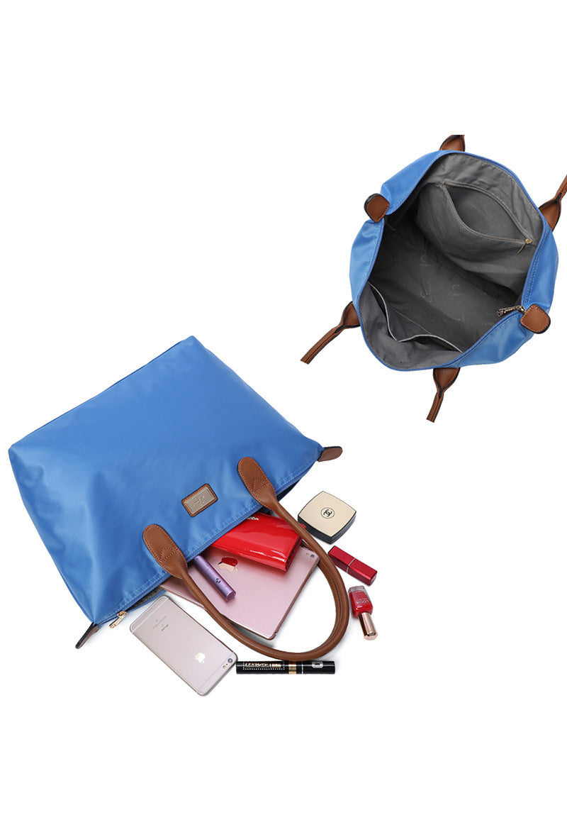 Blue pouch with brown handles and trim, containing various items on a white background