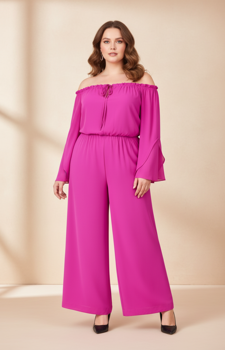 Woman wearing a bright pink off-shoulder jumpsuit on a beige background