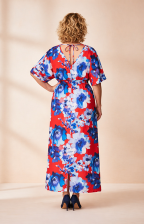 Woman wearing a brown floral dress against a beige background
