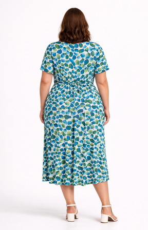 Woman wearing a blue and green patterned dress on a white background