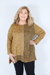 Woman wearing a yellow leopard print top on a white background