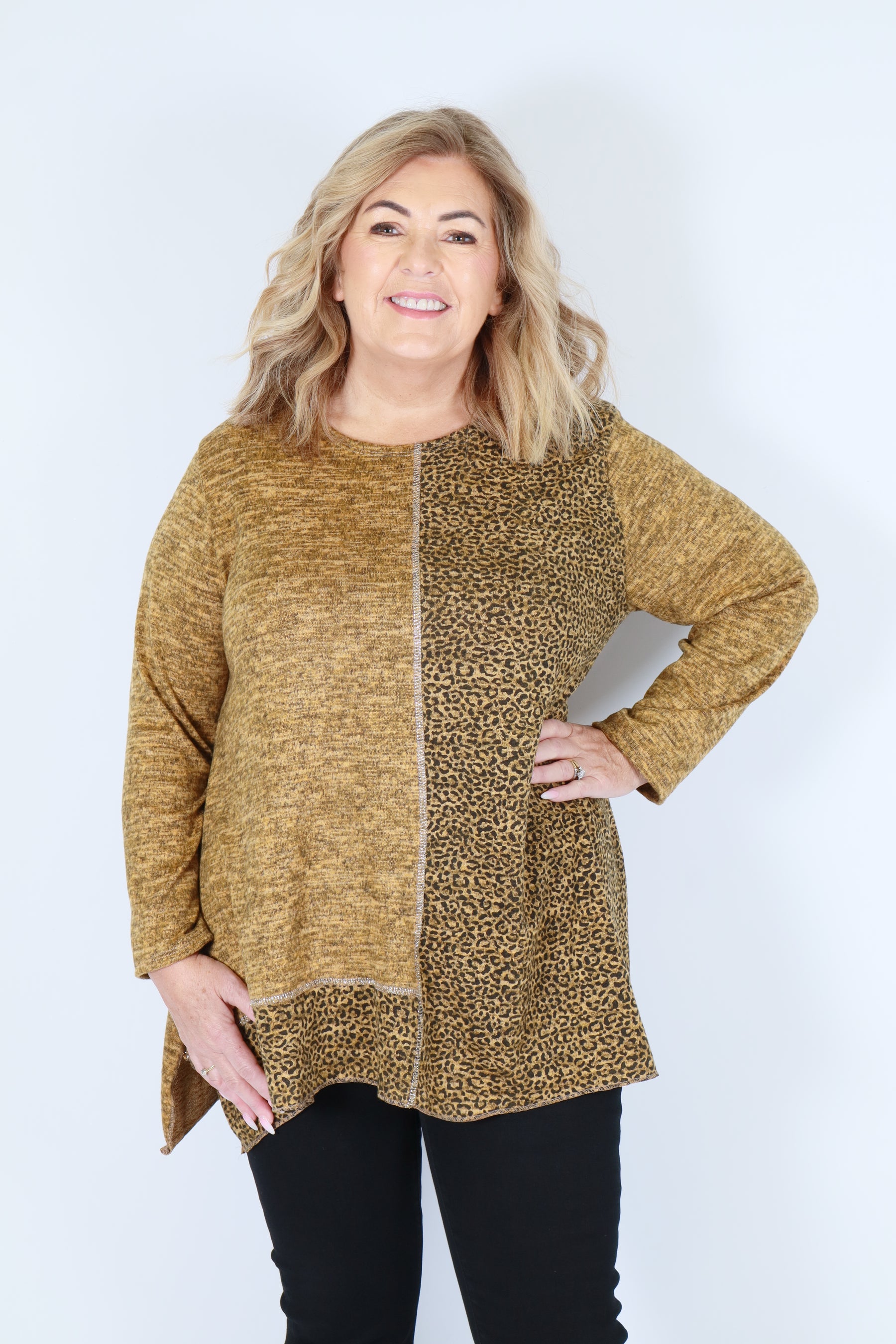Woman wearing a yellow leopard print top on a white background