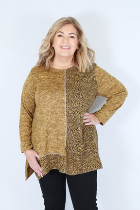 Woman wearing a yellow leopard print top on a white background