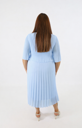 Woman wearing a light blue dress with a pleated skirt on a white background