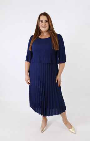 Woman wearing a navy blue pleated dress on a white background