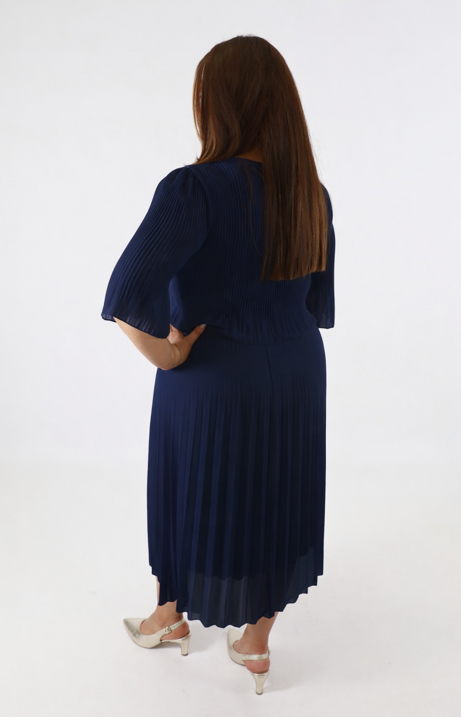 Woman wearing a navy blue dress with puffed sleeves on a white background