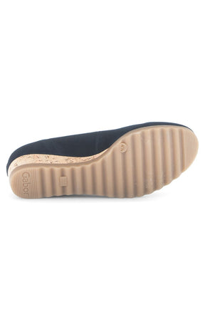 Navy slip-on shoe with a tan sole on a white background 