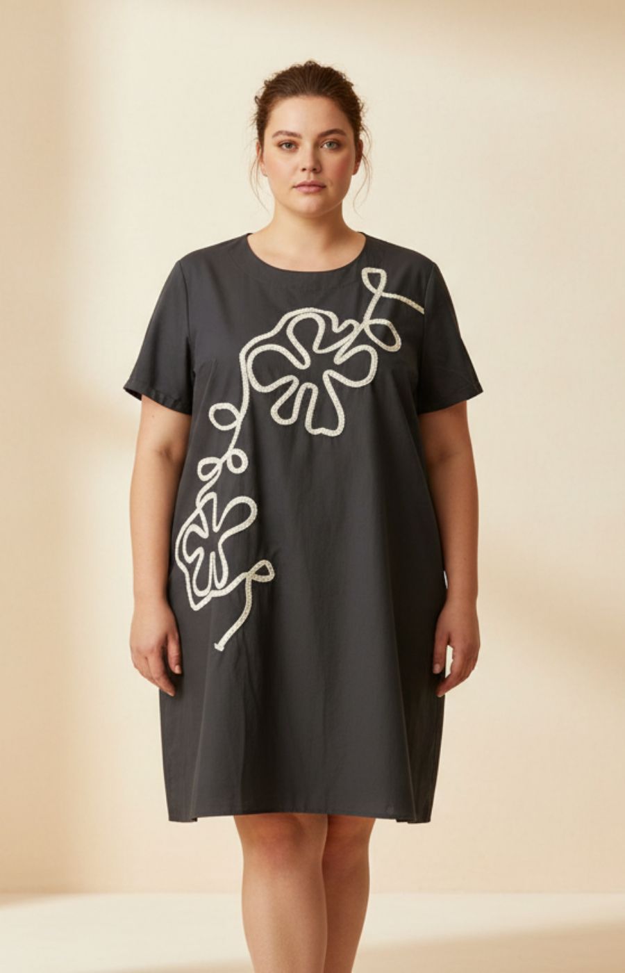 Gabriela Dress in Black, A loose fit dress with an A-line shape, round neckline, short sleeves and a midi length. Also has an embroidered floral design on the front