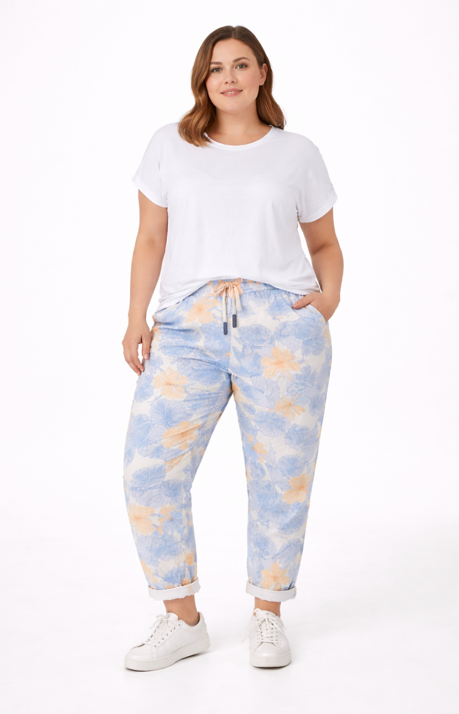 Woman wearing a white t-shirt and blue tie-dye pants on a white background