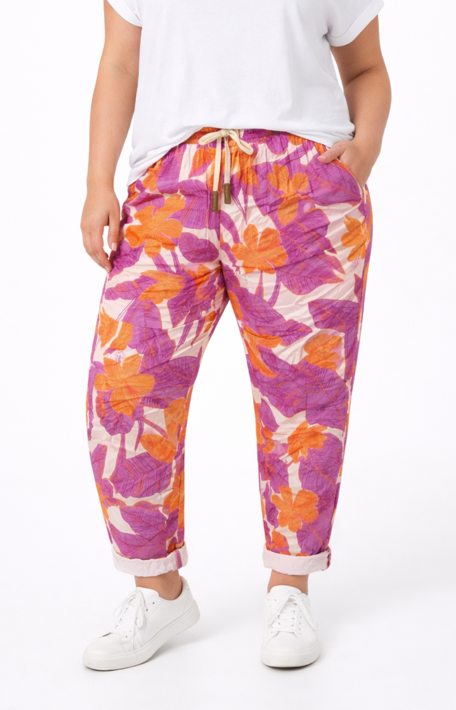 Person wearing colorful floral pants on a white background
