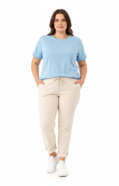 Plus size woman wearing beige pants and a light blue top on a white background