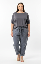 Woman wearing a gray t-shirt and grey joggers on a white background