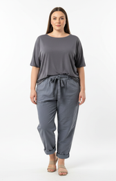 Woman wearing a gray t-shirt and grey joggers on a white background