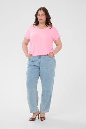 Woman wearing a pink t-shirt and light blue jeans on a white background